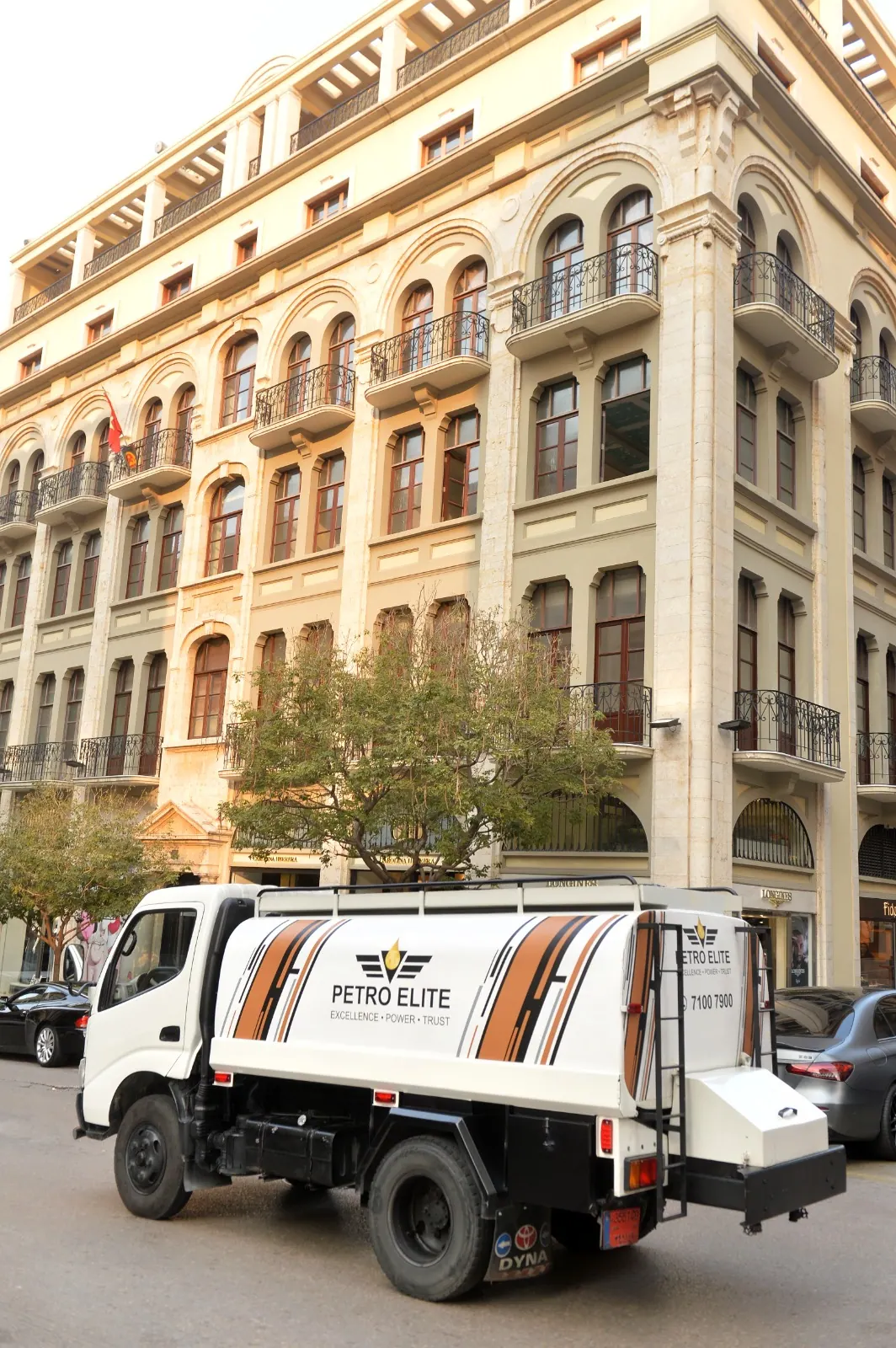 A Petro Elite tanker truck passing a historic building in downtown Beirut